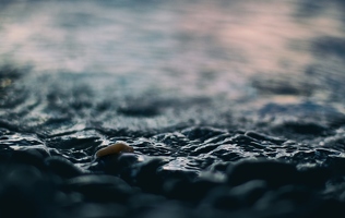 Winzige Wellen, ein Stein, der sich von der Aufgangssonne färben lässt und andere Gründe, flach am Strand zu liegen.